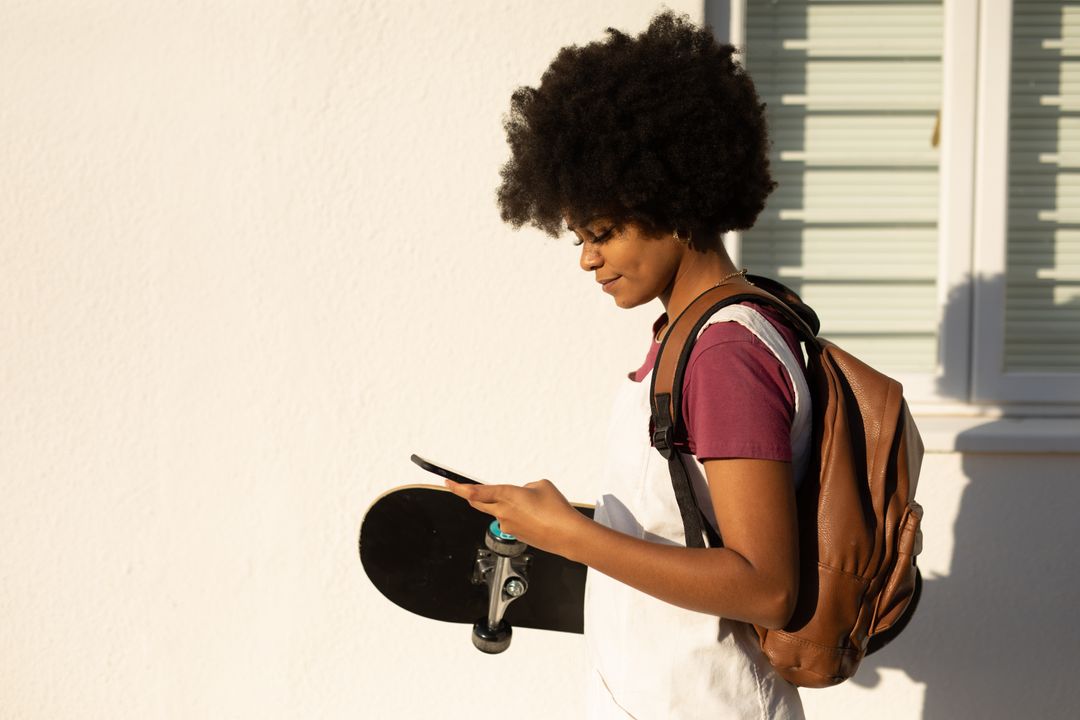 Biracial woman holding skateboard on the street - Free Images, Stock Photos and Pictures on Pikwizard.com