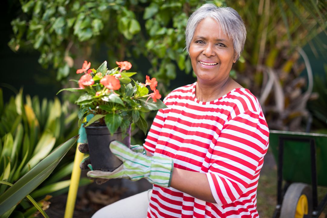 Portrait of smiling woman holding potted plant - Free Images, Stock Photos and Pictures on Pikwizard.com