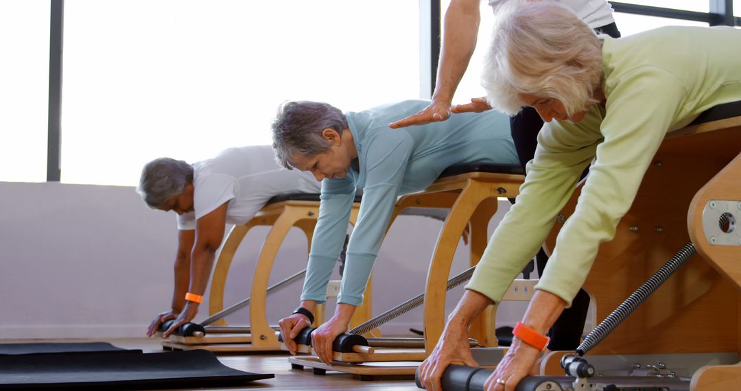 Elderly People Exercising on Pilates Reformers in Wellness Center - Free Images, Stock Photos and Pictures on Pikwizard.com