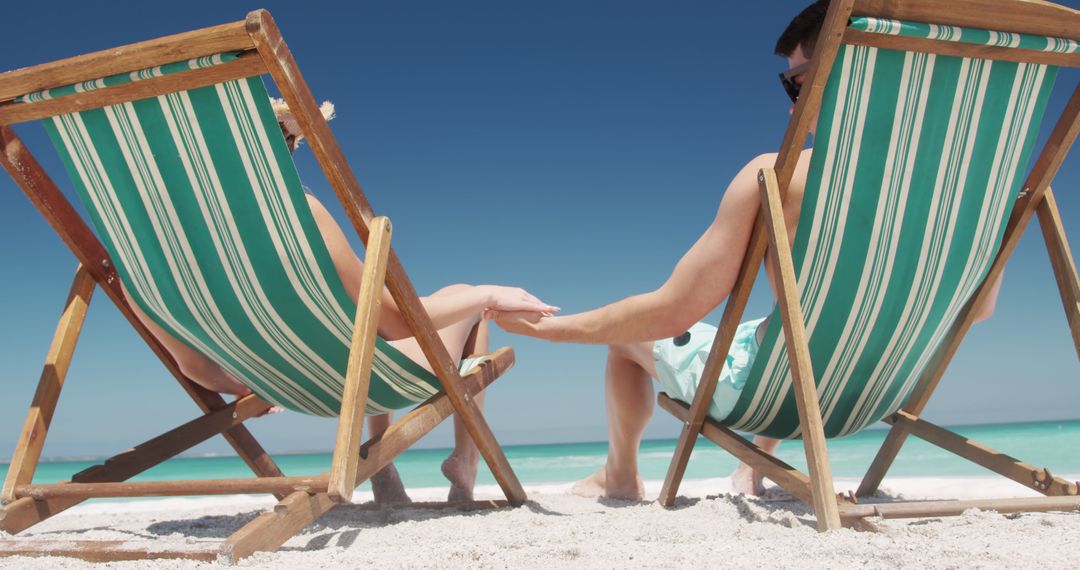 Couple Relaxing on Deck Chairs by the Seashore