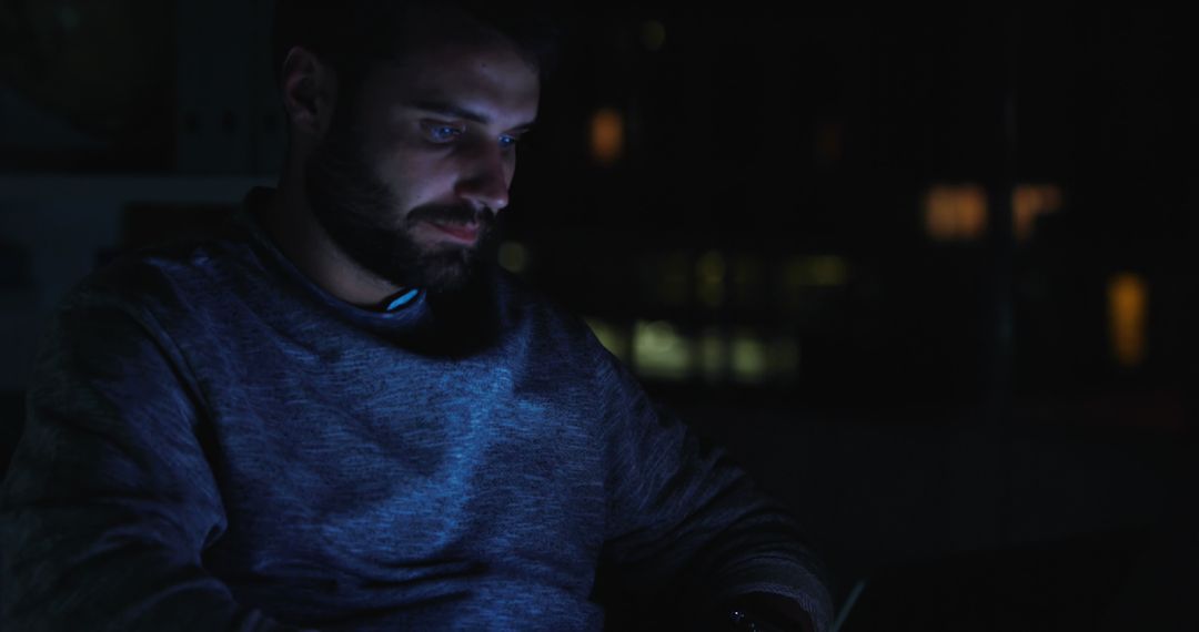 Man Working on Laptop At Night in Dimly Lit Room - Free Images, Stock Photos and Pictures on Pikwizard.com