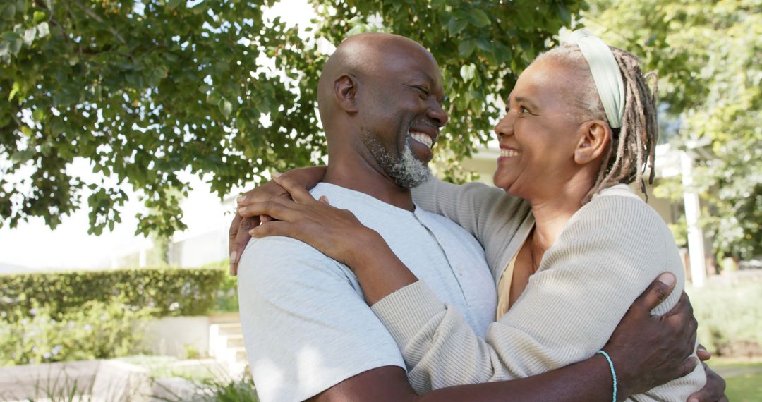 Smiling Senior Couple Embracing in Lush Garden