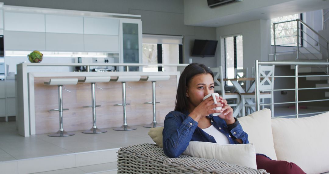 Relaxed Woman Drinking Coffee in Modern Living Room - Free Images, Stock Photos and Pictures on Pikwizard.com