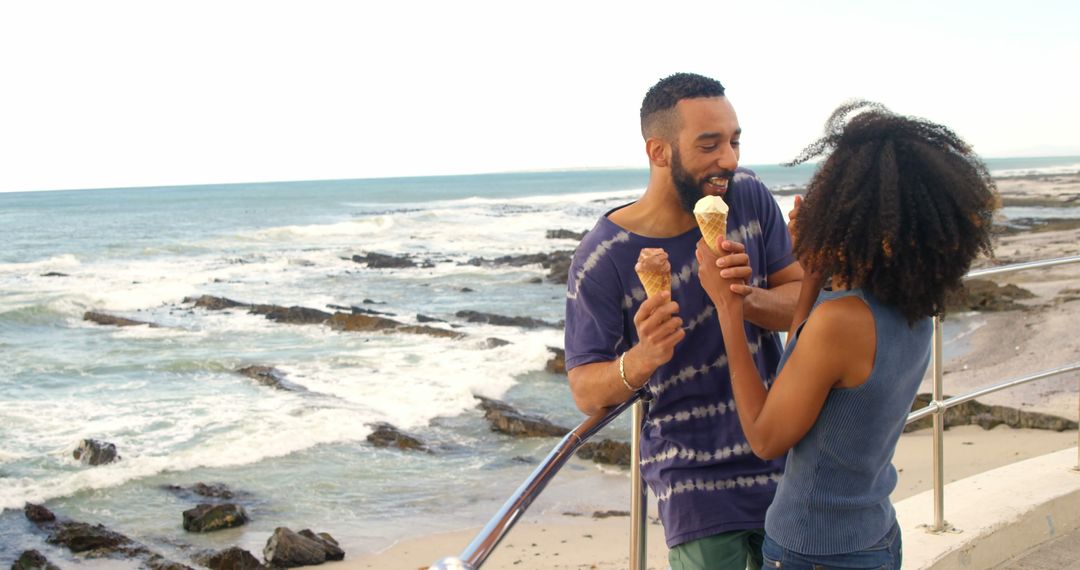 Romantic diverse couple standing by railing and eating ice creams, copy space - Free Images, Stock Photos and Pictures on Pikwizard.com