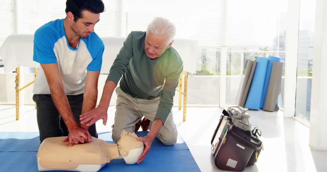 Senior Instructor Teaching CPR To Young Man Indoors - Free Images, Stock Photos and Pictures on Pikwizard.com