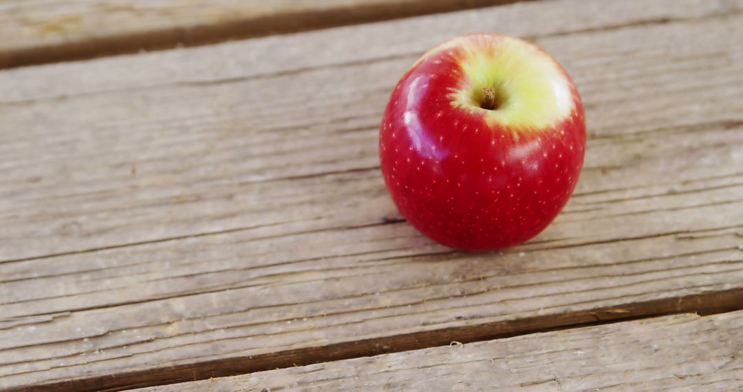 A ripe red apple rests on a wooden surface, with copy space - Free Images, Stock Photos and Pictures on Pikwizard.com