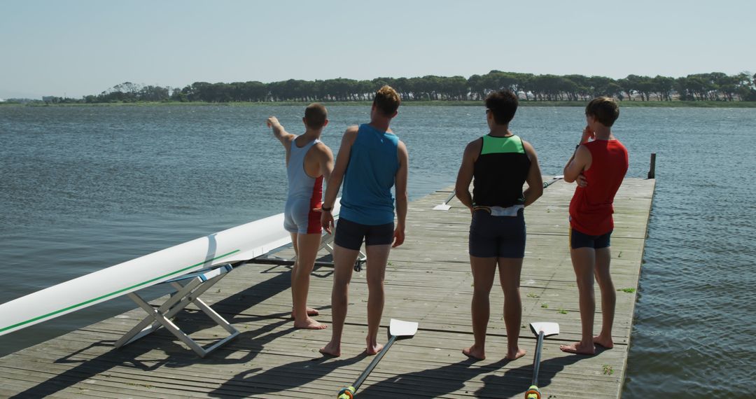 Team of young rowers preparing on lakeside dock - Free Images, Stock Photos and Pictures on Pikwizard.com