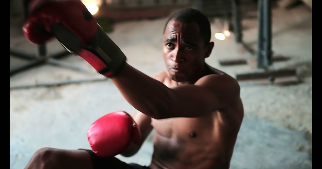 Determined Boxer Practicing Defensive Techniques in Fitness Studio