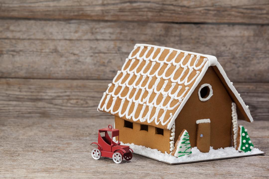 Gingerbread House with Toy Car on Wooden Background - Free Images, Stock Photos and Pictures on Pikwizard.com