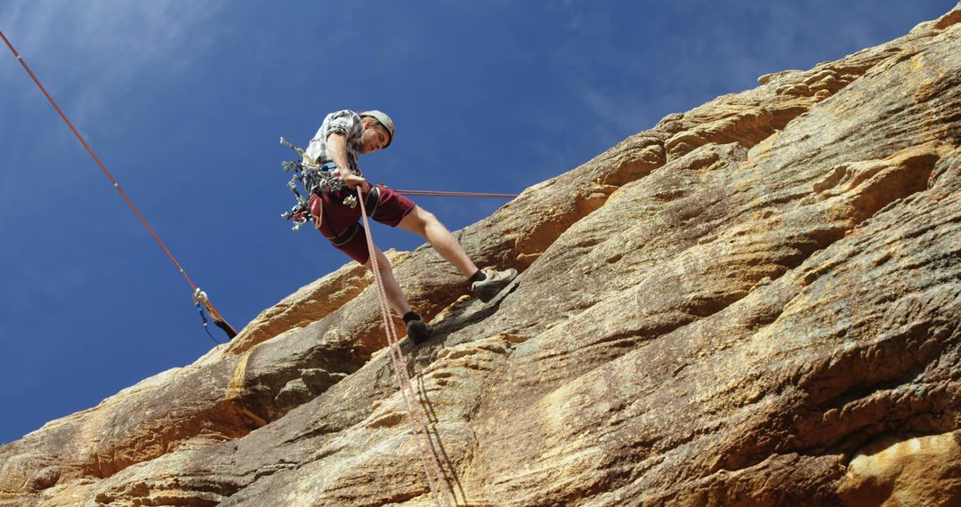 Young Man Rock Climbing Outdoor Cliff Using Safety Gear - Free Images, Stock Photos and Pictures on Pikwizard.com