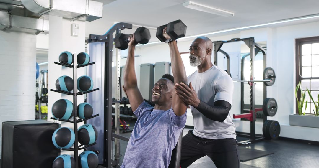 Personal Trainer Assisting Client During Incline Dumbbell Press Workout