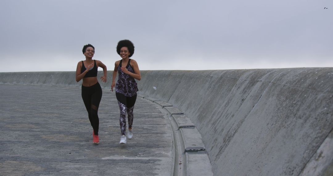 Two Women Jogging on Urban Seawall, Creating Fitness Goals - Free Images, Stock Photos and Pictures on Pikwizard.com