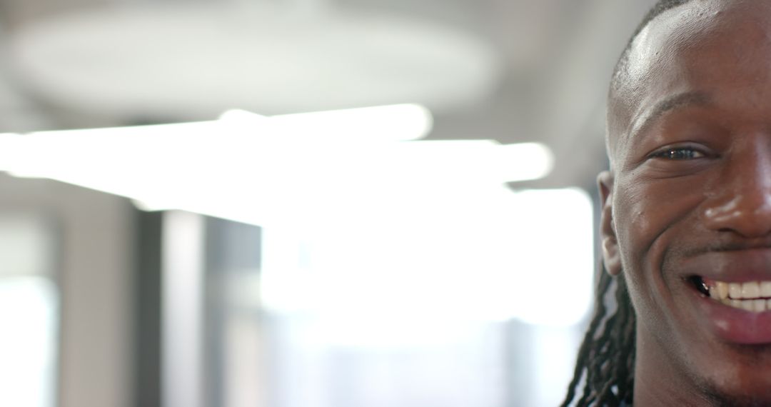 Close-up of Smiling Professional Man with Dreadlocks in Modern Office