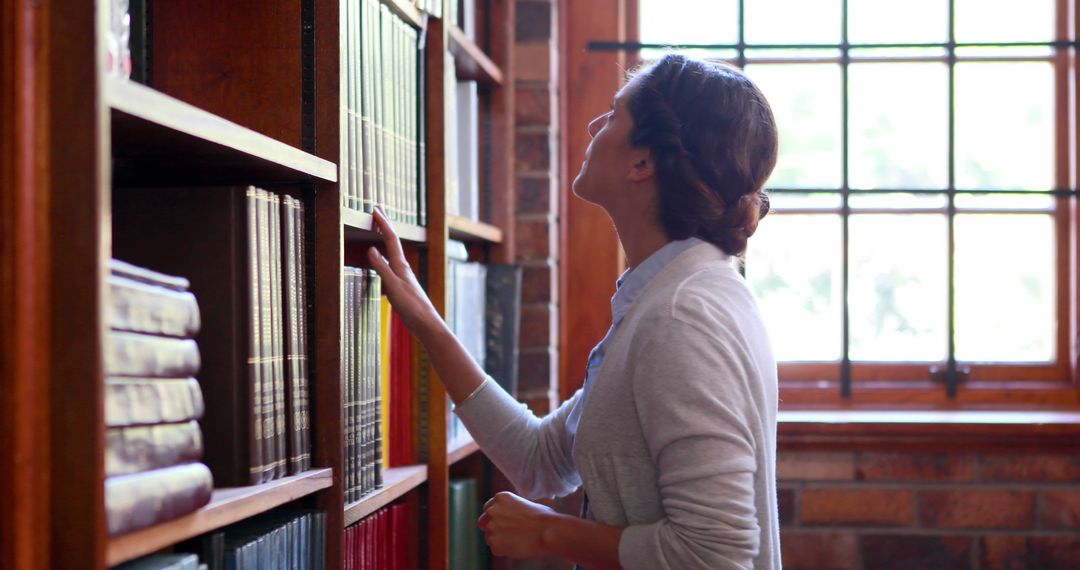 Young Woman Searching for Book in Library - Free Images, Stock Photos and Pictures on Pikwizard.com