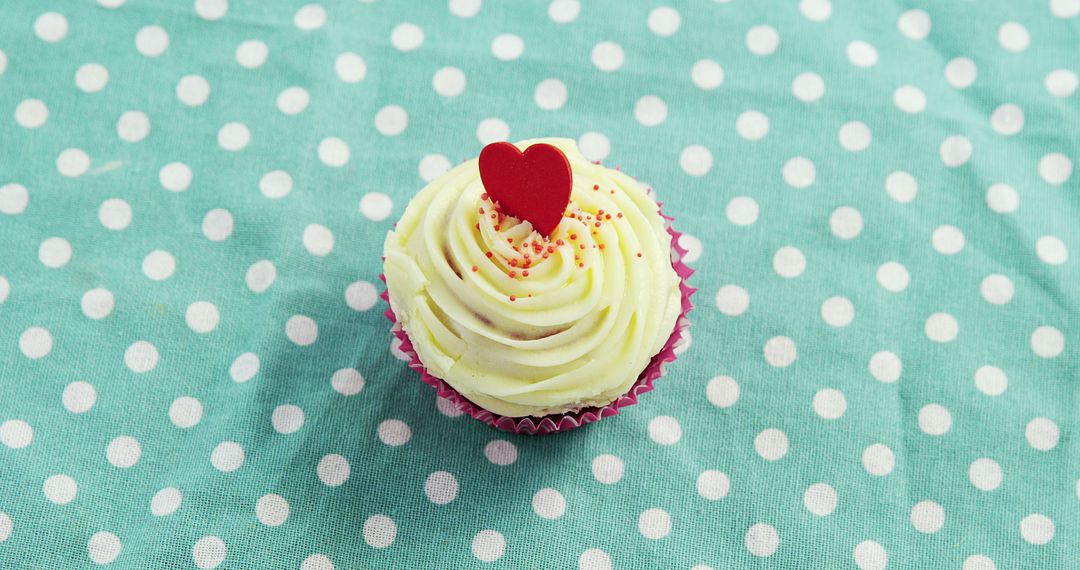 Vanilla Cupcake with Heart Topper on Polka Dot Fabric