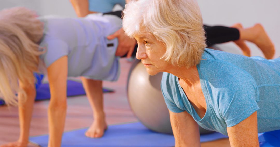 Elderly woman practicing yoga in group class - Free Images, Stock Photos and Pictures on Pikwizard.com