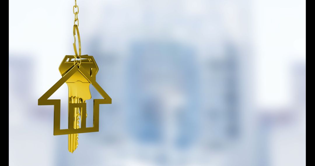 Golden house key with house-shaped keychain over blurred background