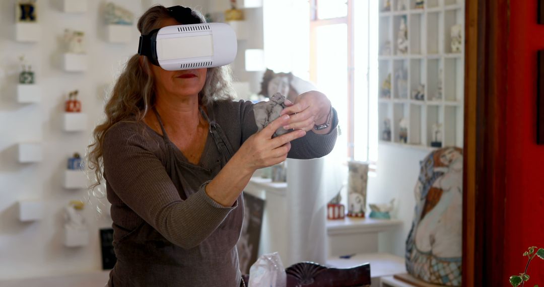 Elderly Woman with VR Goggles Handling Ceramic Art Piece in Studio - Free Images, Stock Photos and Pictures on Pikwizard.com