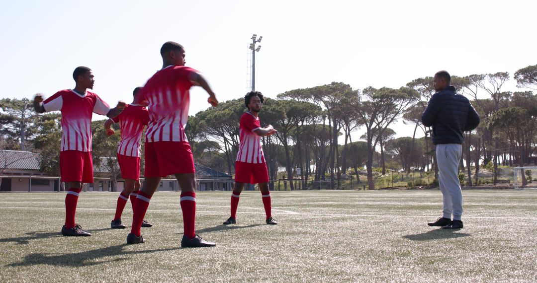 Soccer Team in Red Uniforms Warming Up for Match