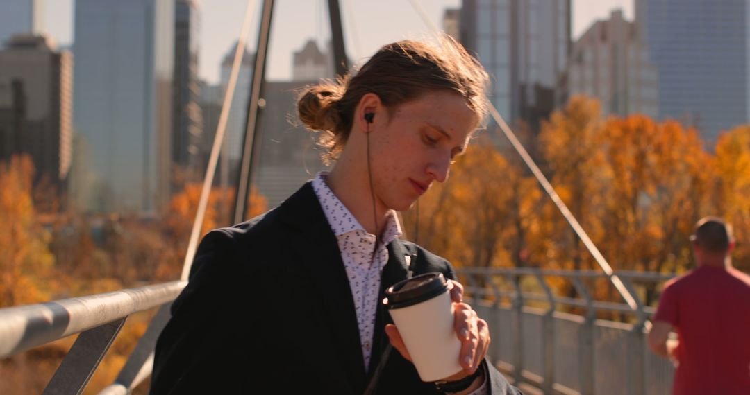 Young Professional Listening to Music with Coffee on Urban Bridge - Free Images, Stock Photos and Pictures on Pikwizard.com