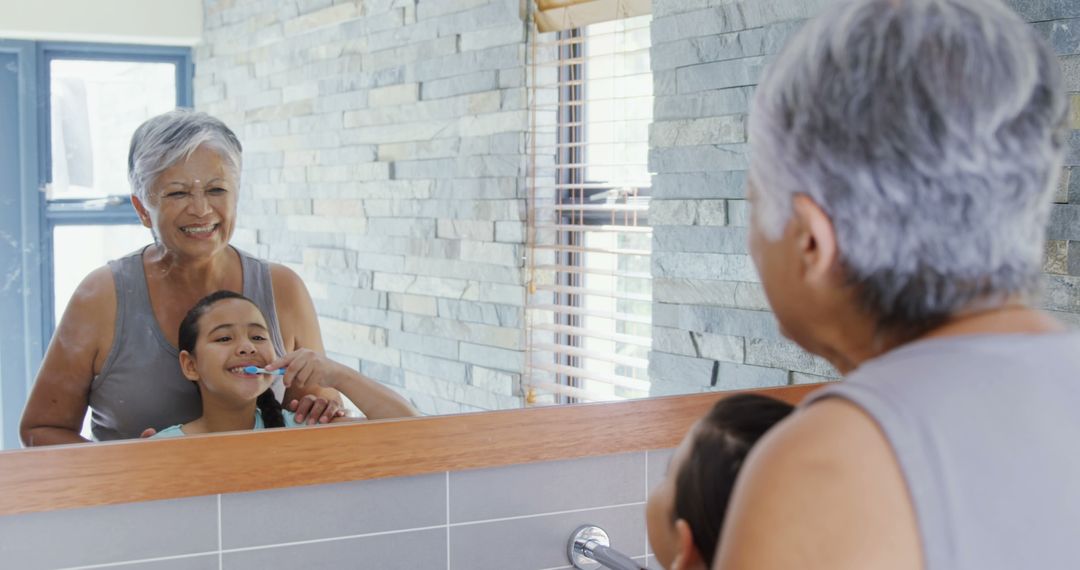 Senior Woman Assisting Child Brushing Teeth in Modern Bathroom Mirror - Free Images, Stock Photos and Pictures on Pikwizard.com