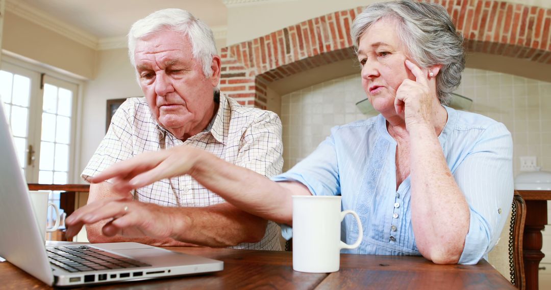 Senior Couple Using Laptop at Kitchen Table - Free Images, Stock Photos and Pictures on Pikwizard.com