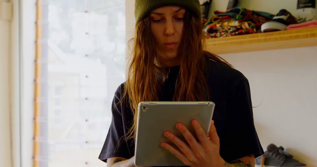 Young Woman Wearing Beanie Using Tablet Indoors - Free Images, Stock Photos and Pictures on Pikwizard.com