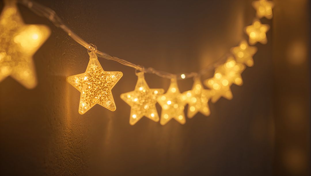 Glowing star LED string lights casting warm golden bokeh glow on textured wall