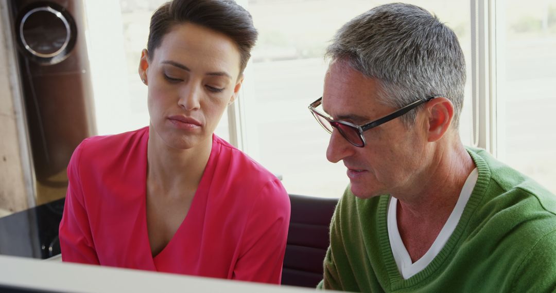 Two Business Colleagues Collaborating at Office Desk with Computer
