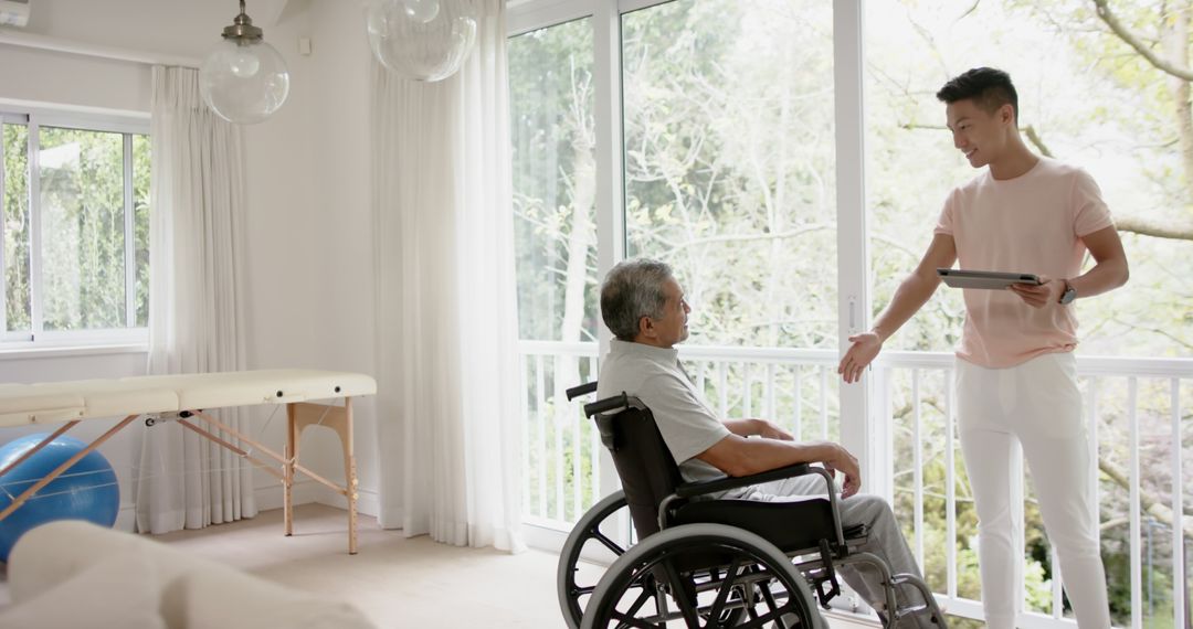 Young Man and Elderly Man in Wheelchair Engaging in Conversation at Home - Free Images, Stock Photos and Pictures on Pikwizard.com