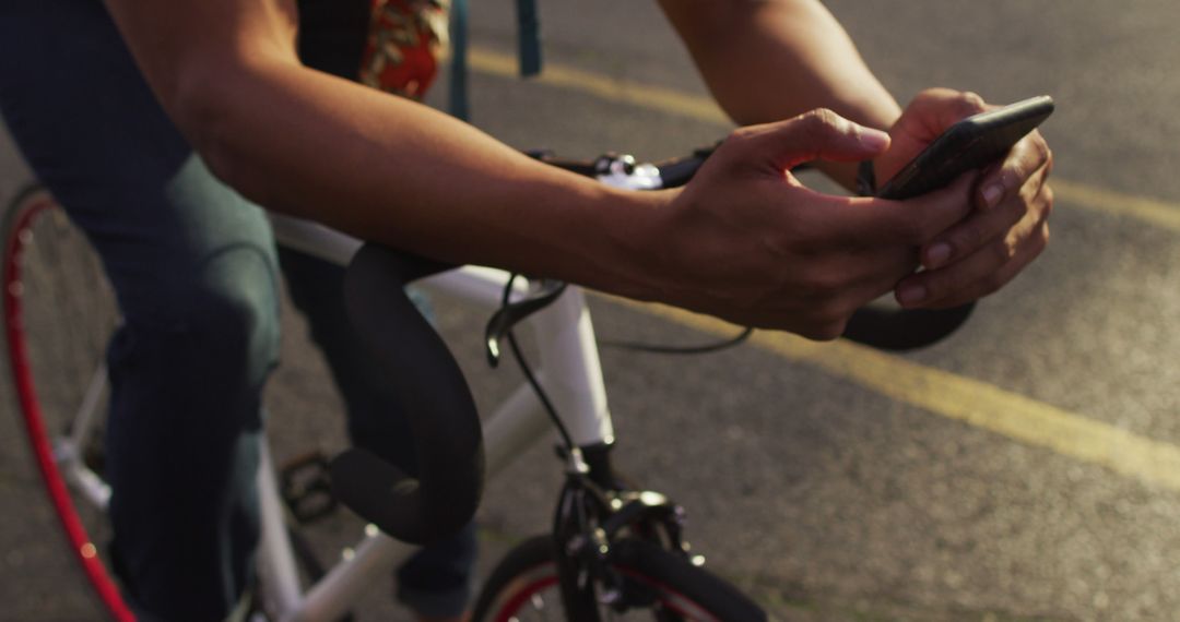 Cyclist Checking Smartphone While Riding Bicycle Outdoors - Free Images, Stock Photos and Pictures on Pikwizard.com