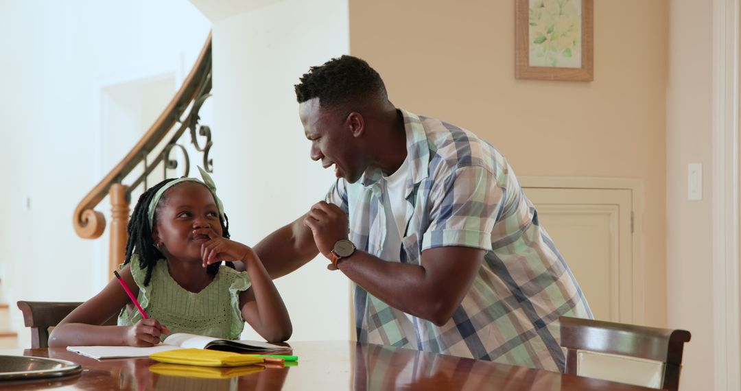 Father Helping Daughter with Homework at Dining Table