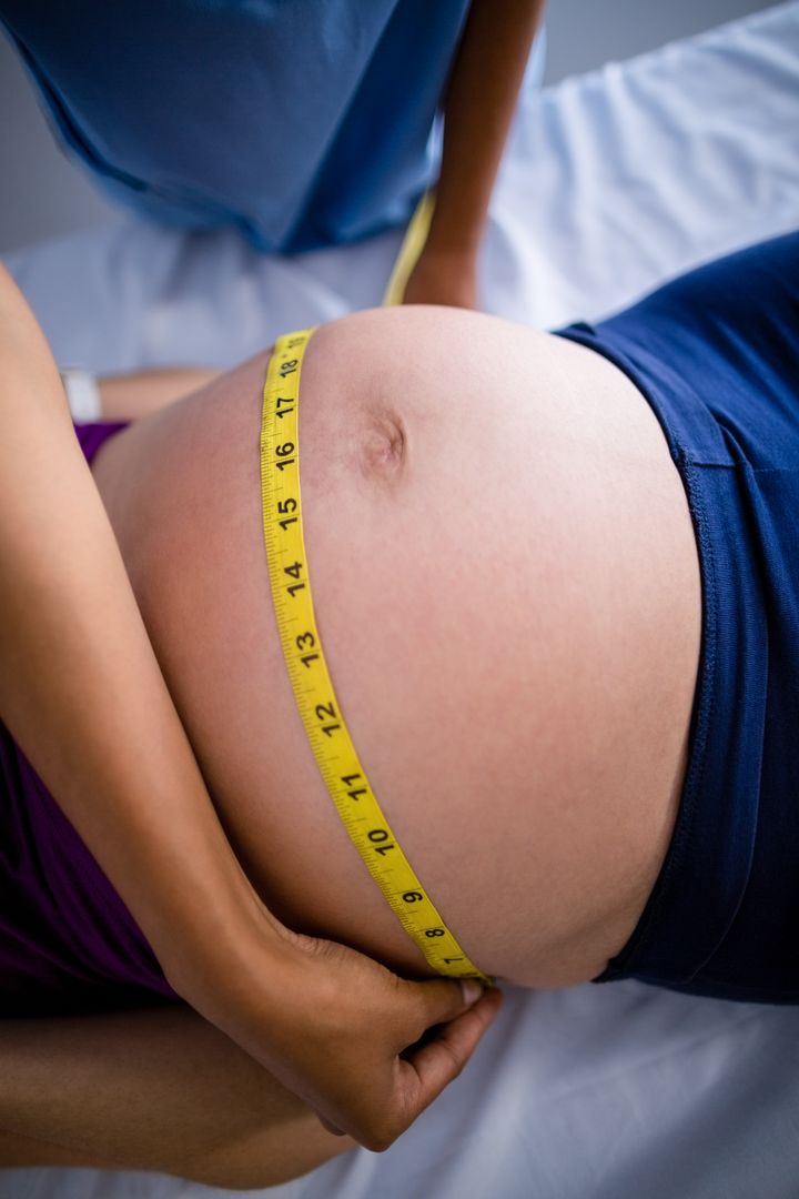 Doctor measuring pregnant womans belly in ward - Free Images, Stock Photos and Pictures on Pikwizard.com