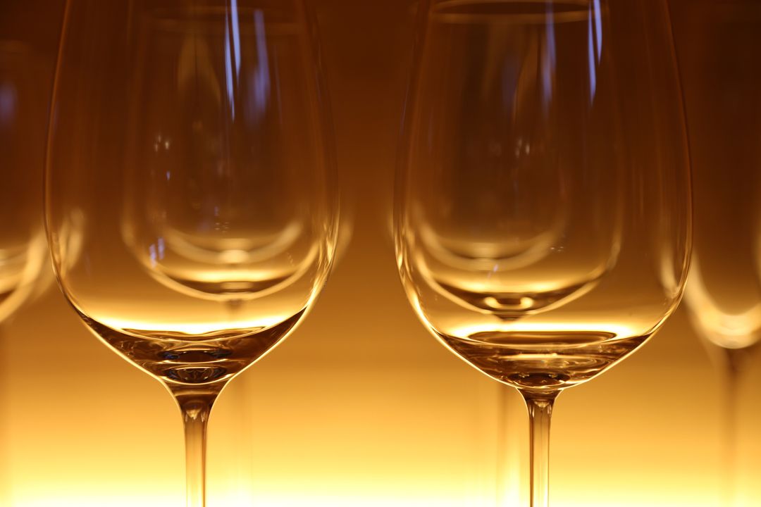 Crystal Wine Glasses Glowing Under Warm Golden Light Elegant Close-Up Reflection