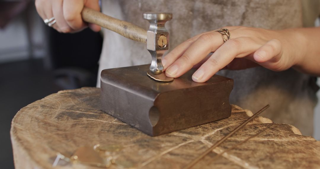 Jewelry Maker Hammering Metal on Wooden Block in Workshop - Free Images, Stock Photos and Pictures on Pikwizard.com