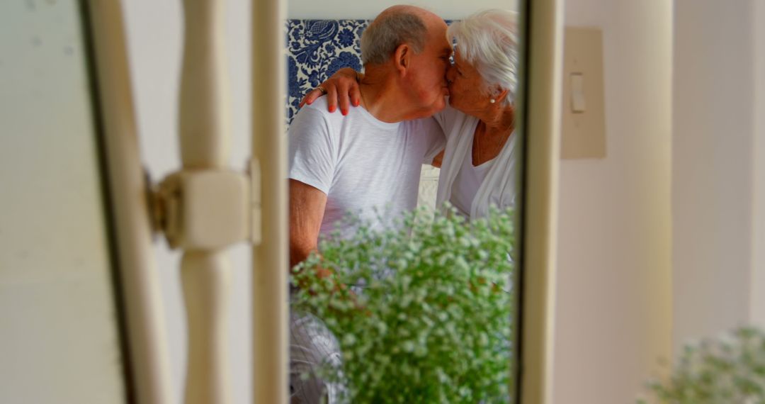 Elderly Couple Kissing Affectionately Through Window Reflection - Free Images, Stock Photos and Pictures on Pikwizard.com