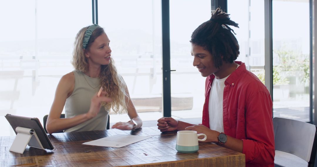 Young Professionals Collaborating at Work with Documents and Tablet