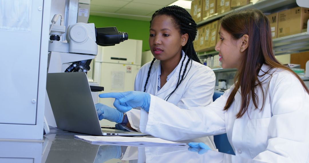 Female Scientists Collaborating in Laboratory Setting using Microscope and Laptop - Free Images, Stock Photos and Pictures on Pikwizard.com