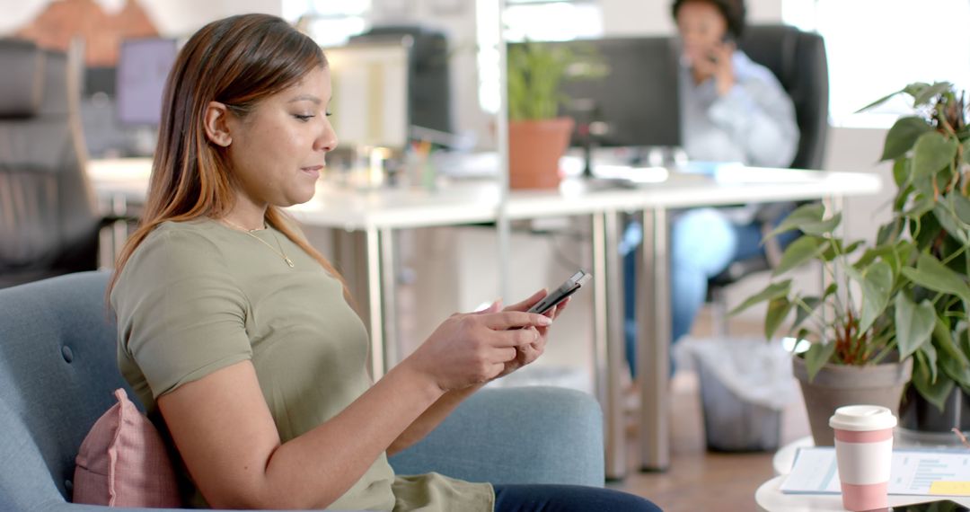 Young Woman Using Smartphone in Modern Office Lounge - Free Images, Stock Photos and Pictures on Pikwizard.com