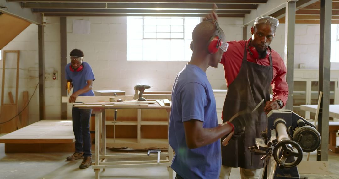 African American Instructor with Trainees in Carpentry Workshop