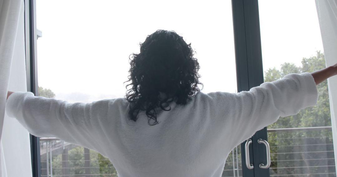 Woman in White Bathrobe Opening Curtains to a Bright Window - Free Images, Stock Photos and Pictures on Pikwizard.com