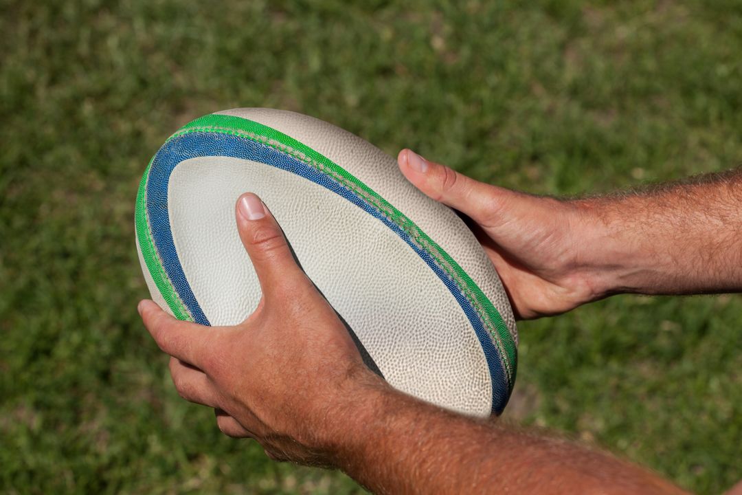 High angle view of hands holding rugby ball - Free Images, Stock Photos and Pictures on Pikwizard.com