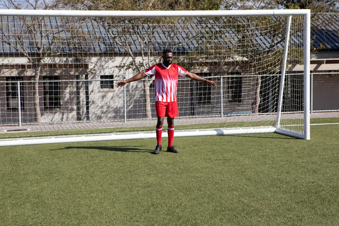 Athlete Practicing Soccer in Red and White Jersey on Turf