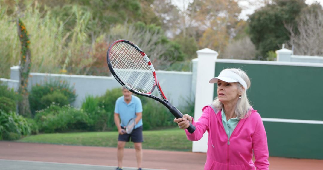 Senior Woman Preparing to Hit Tennis Ball on Court - Free Images, Stock Photos and Pictures on Pikwizard.com