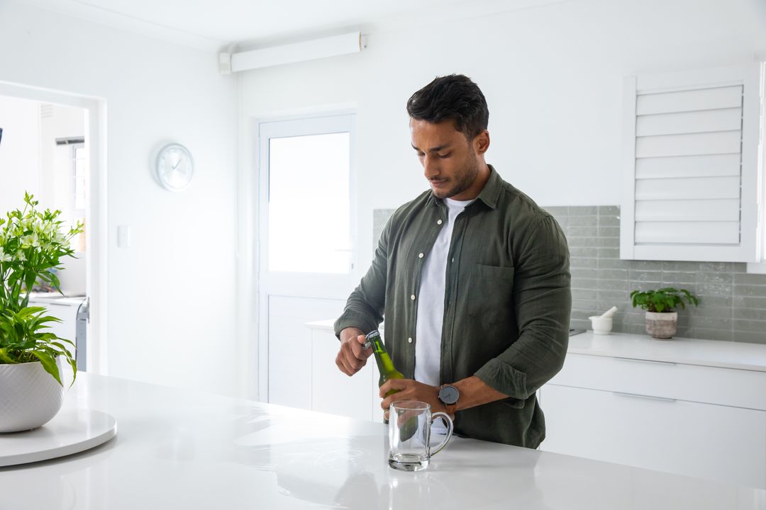 Man Opening Drink Bottle in Sleek Modern Kitchen