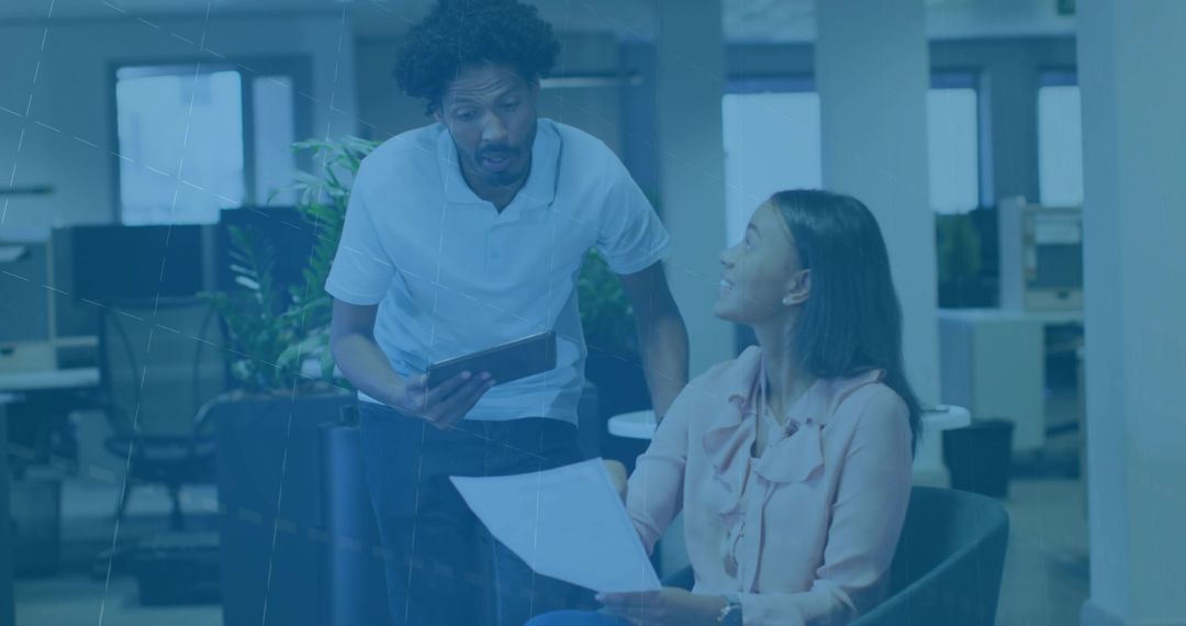 Team Discussion in Casual Office Environment with Tablet and Document