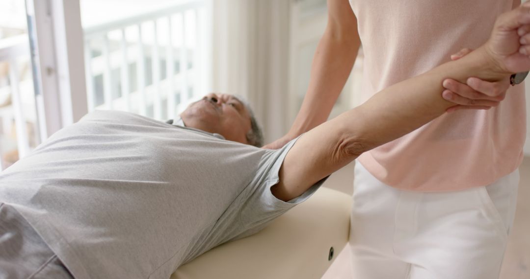 Physical Therapist Helping Elderly Patient with Shoulder Stretch - Free Images, Stock Photos and Pictures on Pikwizard.com