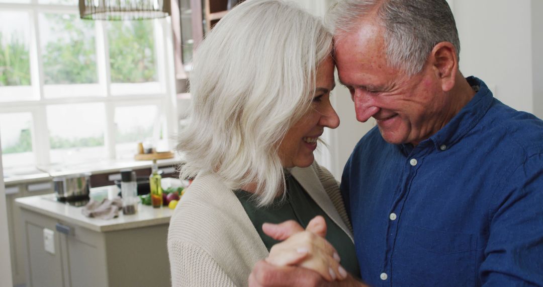 Happy Senior Couple Embracing and Dancing in Kitchen - Free Images, Stock Photos and Pictures on Pikwizard.com