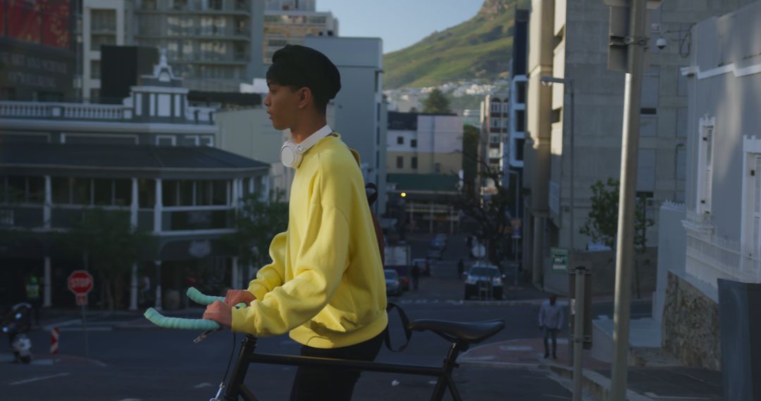 Young Man in Yellow Sweatshirt Riding Bicycle in Urban City - Free Images, Stock Photos and Pictures on Pikwizard.com