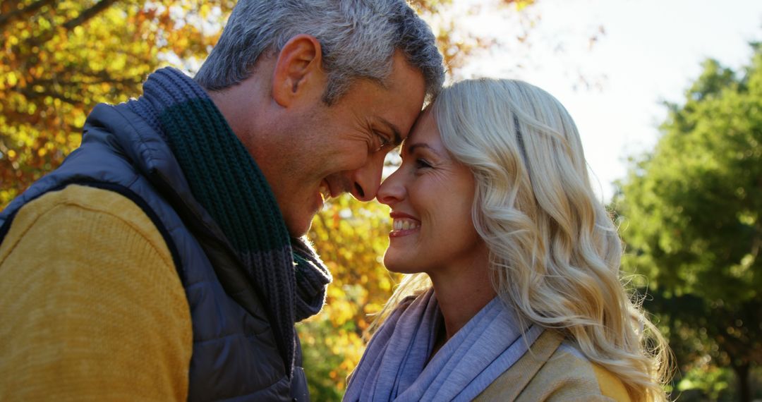 Smiling Couple Touching Foreheads in Autumn Park - Free Images, Stock Photos and Pictures on Pikwizard.com